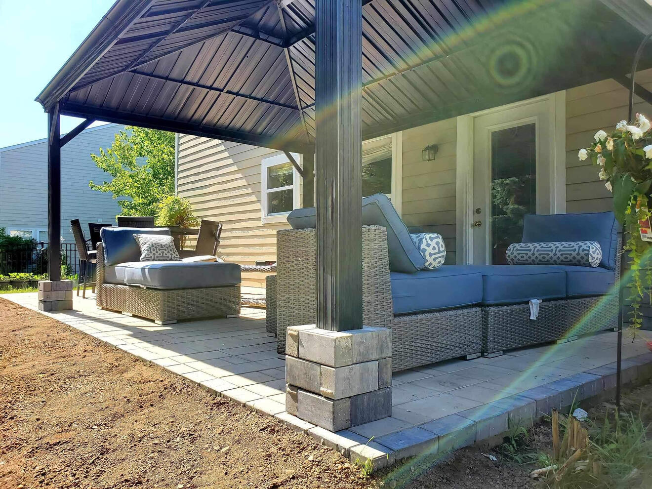 Refreshing outdoor patio in Indianapolis with a patio awning and neatly trimmed hedges framed by mulch.