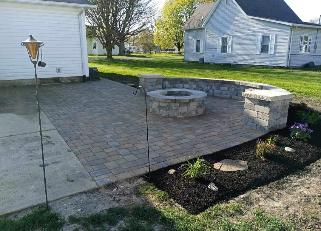 Inviting backyard patio with fire pits, surrounded by fresh brown mulch, in an Indianapolis home.