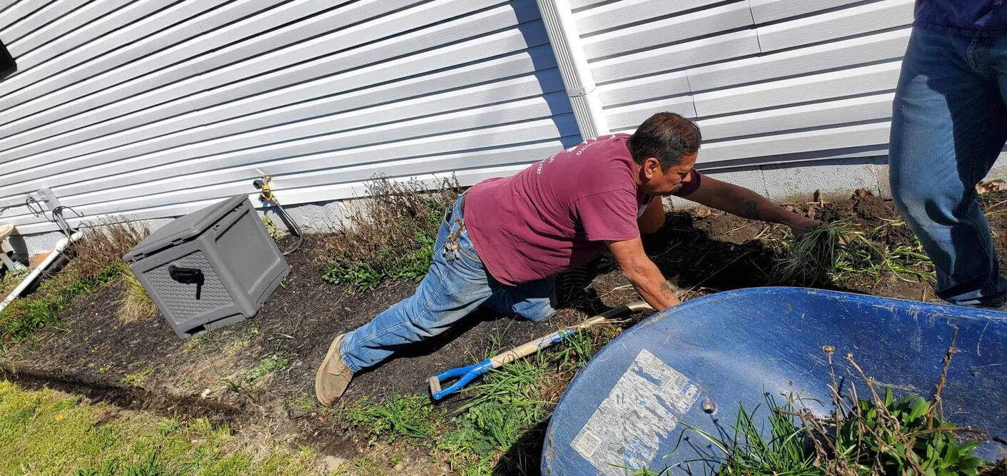 Professional landscaper working on a residential project in Indianapolis, featuring the before of a custom yard design project.